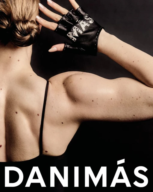 A woman's back and upper arm with a black fingerless glove on her hand is displayed on a black background with a text overlay.