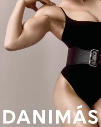 Close-up portrait of a woman in a black bodysuit with a wide belt against a grey studio seamless backdrop