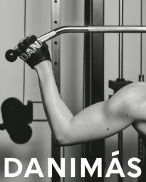 Close-up monochrome image of an arm gripping a gym cable machine handle, wearing a glove with the text DANIMAS.