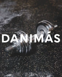 Close-up of a metallic dumbbell resting on a dark rubber gym floor with white chalk dust