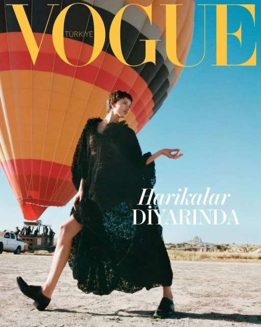 Vogue Türkiye cover featuring a fashion model in a black dress posing in a desert landscape with a hot air balloon and car in the background.