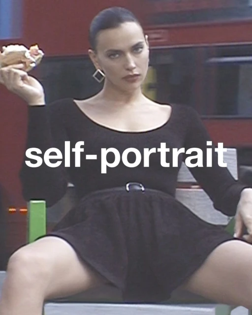 Adult female sitting, holding food, wearing a black long-sleeve dress and square earrings in front of a blurred red vehicle.