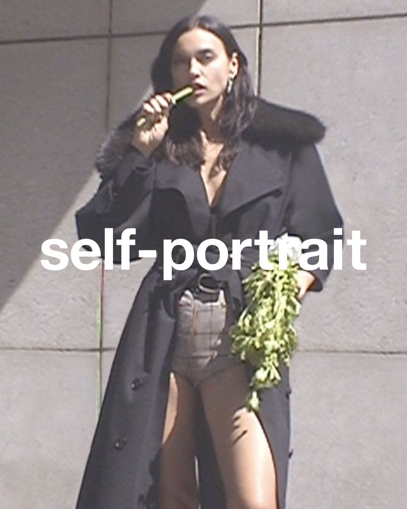 Adult female in a long coat poses outdoors holding fresh produce; a large white self-portrait text overlay is visible.