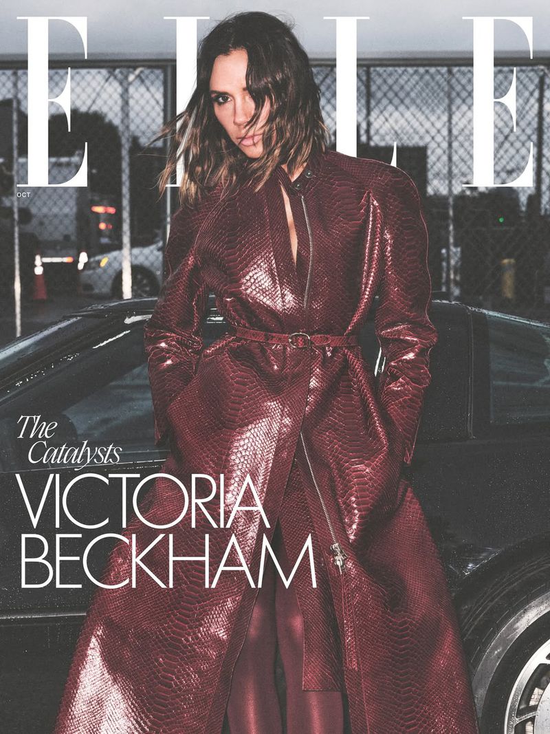 Magazine cover featuring Victoria Beckham wearing a long, maroon leather coat with a car and urban setting in the background.