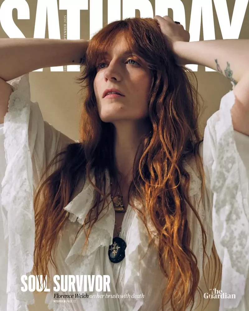A middle-aged man with salt and pepper hair stands in a photo studio, wearing a blazer, dress shirt, and jeans, captured in a medium shot.