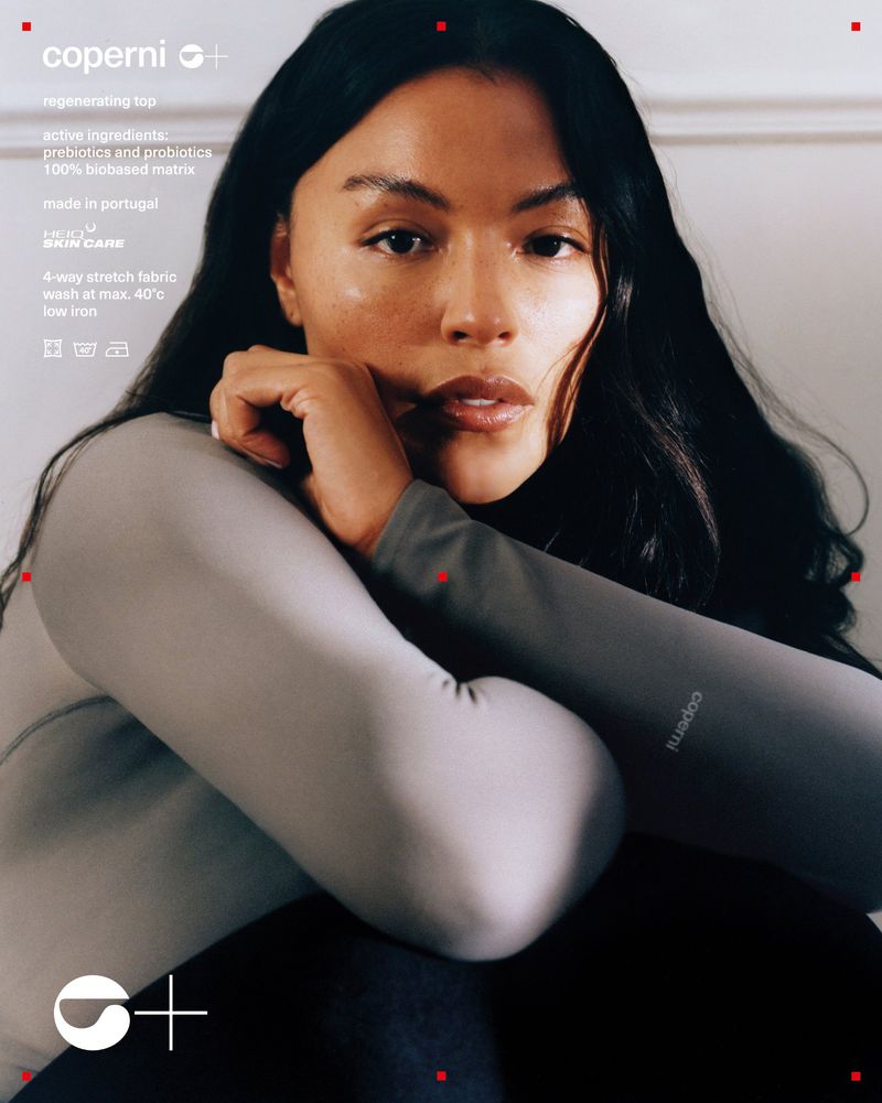 Brunette woman posing in Coperni top; gray long-sleeve, fashion ad. Active ingredients, prebiotics, probiotics. Made in Portugal.