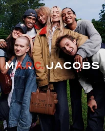 Group of smiling models outdoors showcasing the Marc Jacobs x A.P.C. brown leather tote bag and utility outerwear.