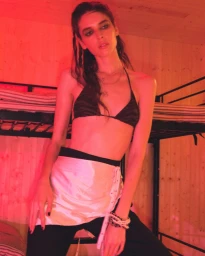 Model Libby Taverner posing against bunk beds under red light for Pop Magazine shot by Oliver Hadlee Pearch.