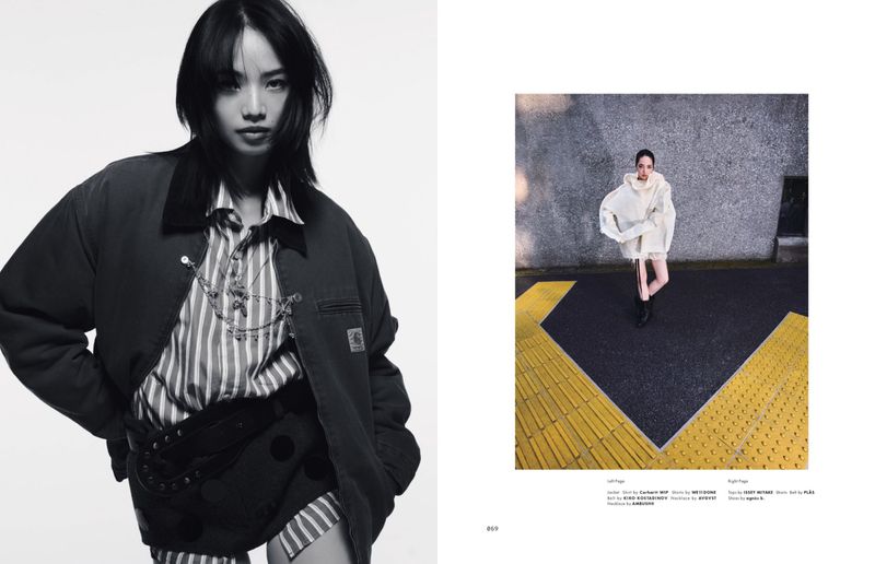 Fashion editorial shot with an Asian model wearing a Carhartt jacket and striped shirt, posing in a photo studio on white background.