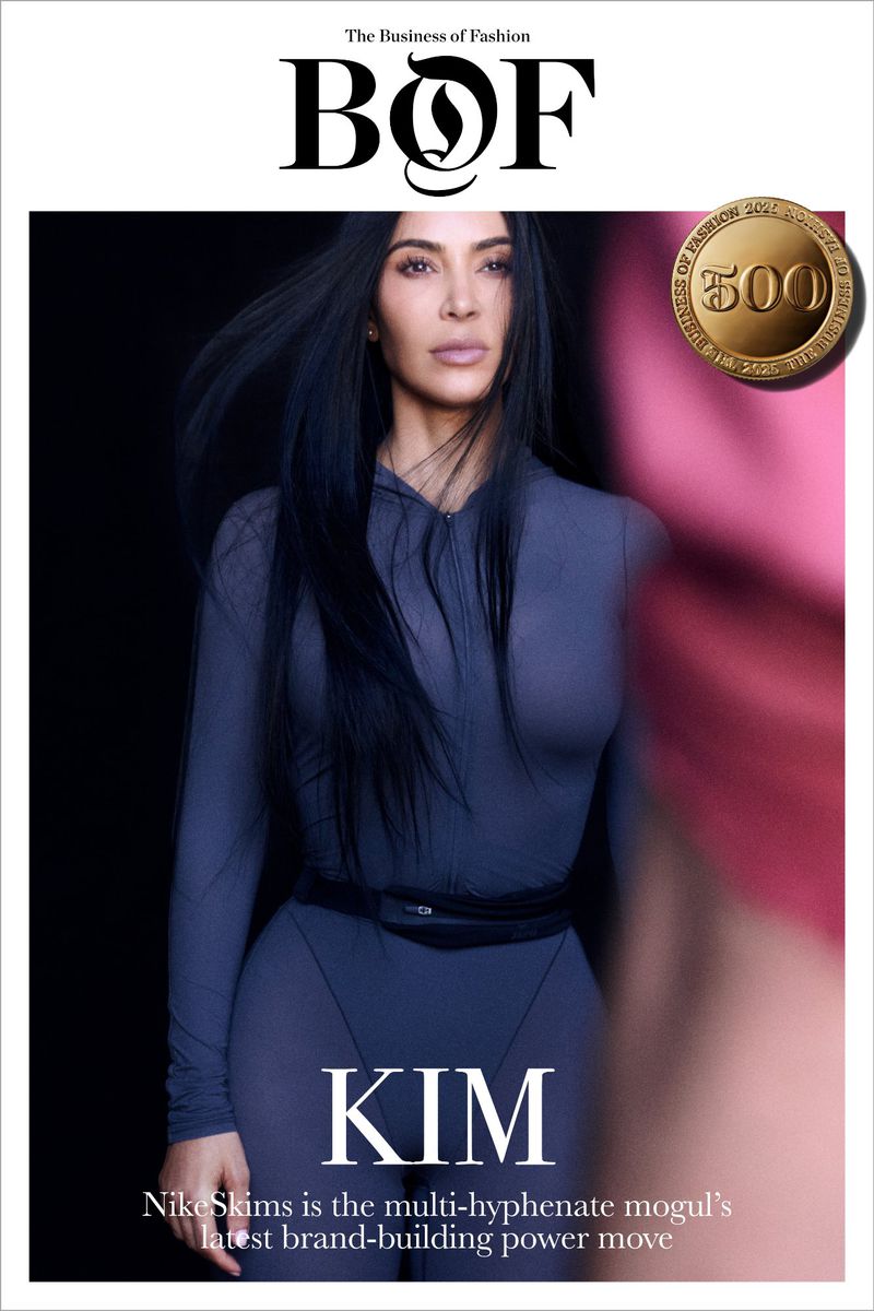 Magazine cover featuring Kim Kardashian in a gray bodysuit, set against a dark background with branding and text.