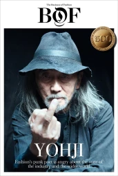 Japanese fashion designer Yohji Yamamoto wearing a black textured hat and dark shirt on a magazine cover portrait.