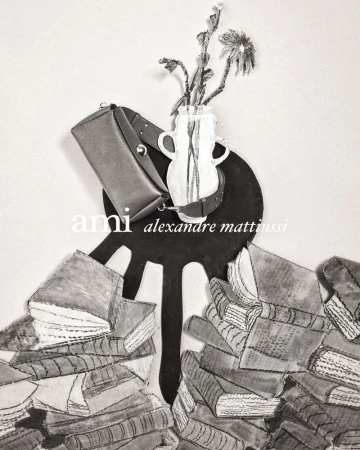 Still life image with a bag, books, and flowers in a vase, set against a neutral backdrop, conveying a sense of academic fashion and style.