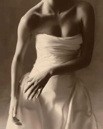 Elegant studio portrait of a woman in a draped dress, showcasing neutral colors, soft lighting, and fine art photography technique.