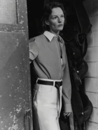 Model Sara Blomqvist wearing a collared button-down shirt and belted trousers in a monochrome editorial portrait for Giada.