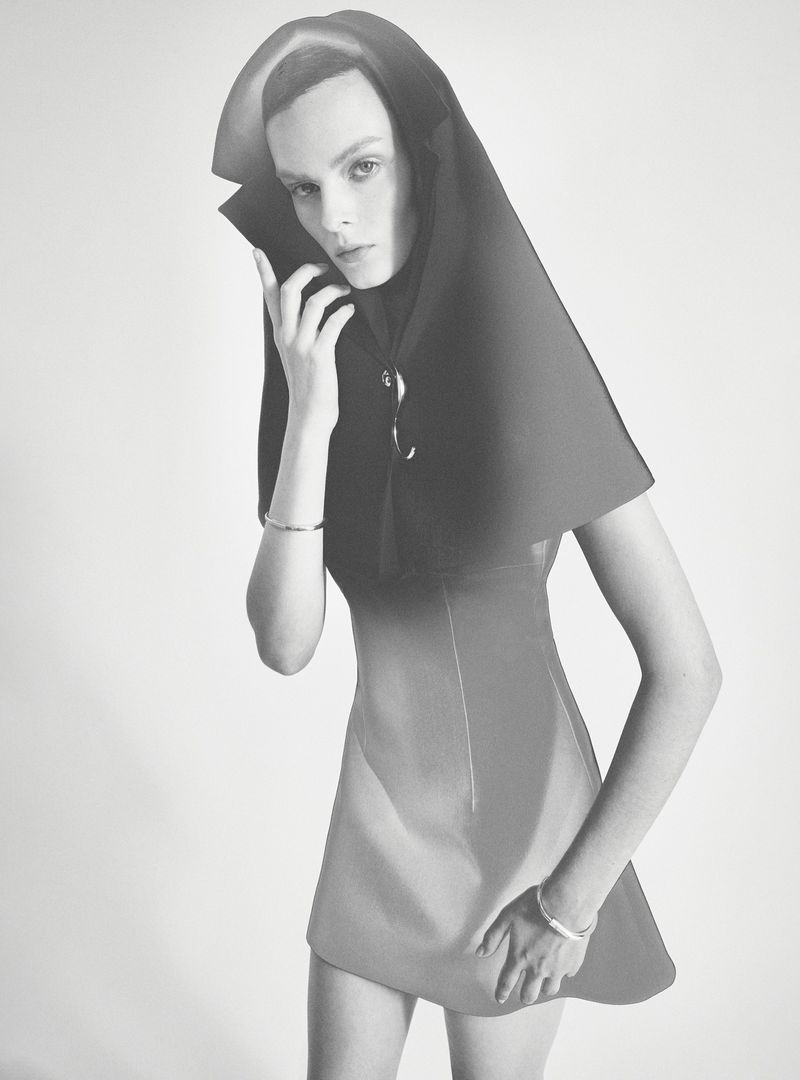 Model Aylah Peterson wearing a structured dark sculptural hood and dress against a white seamless background for Rush love project