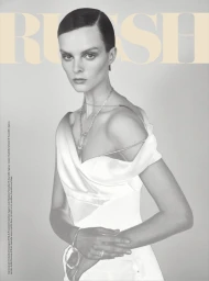 Aylah Peterson wearing an off-shoulder white dress and silver jewelry against a grey studio backdrop for Rush magazine.