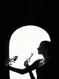 Silhouette of a woman holding keys and a padlock against a bright arched backdrop