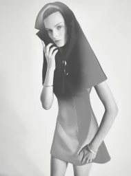 Model Aylah Peterson wearing a structured dark sculptural hood and dress against a white seamless background for Rush love project