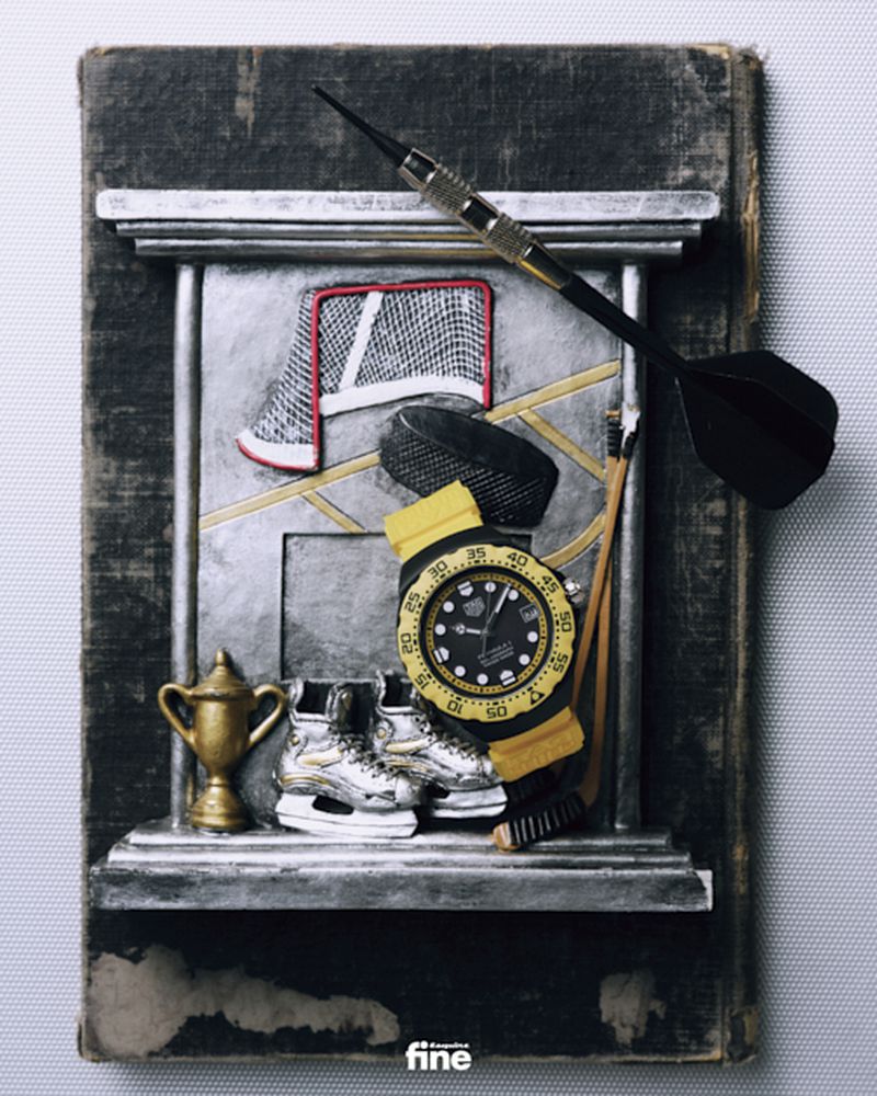 Still life with hockey equipment, ice skates, a trophy, a watch and a dart on a book. Close-up studio shot with detailed textures.