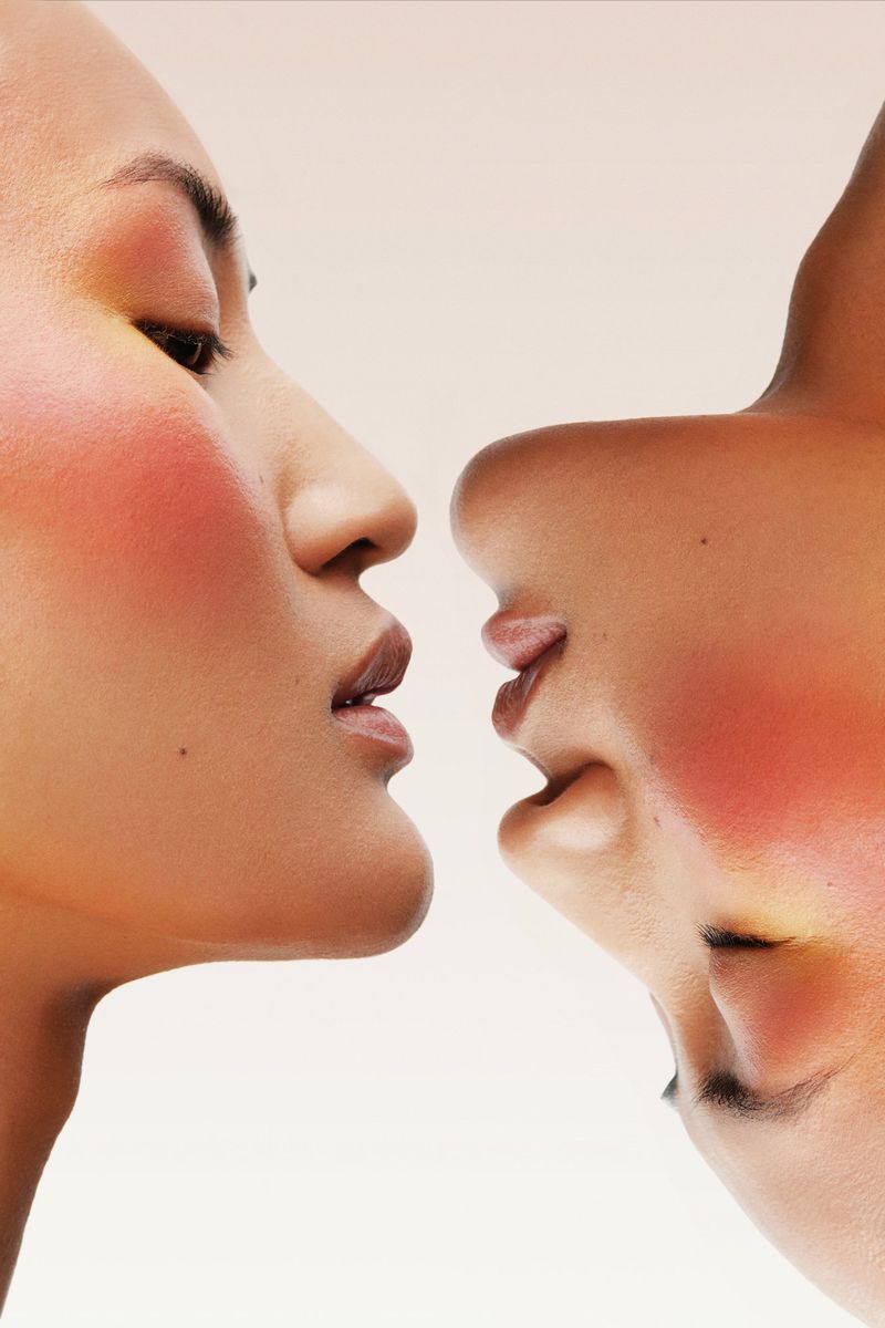 Close-up studio shot of two Asian women with similar skin tones, one upright and the other inverted, in a beauty concept.