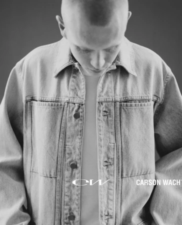 Close-up portrait of a young man wearing a light denim jacket looking down, photographed by Wade Schaul for Carson Wach Spring/Summer 25