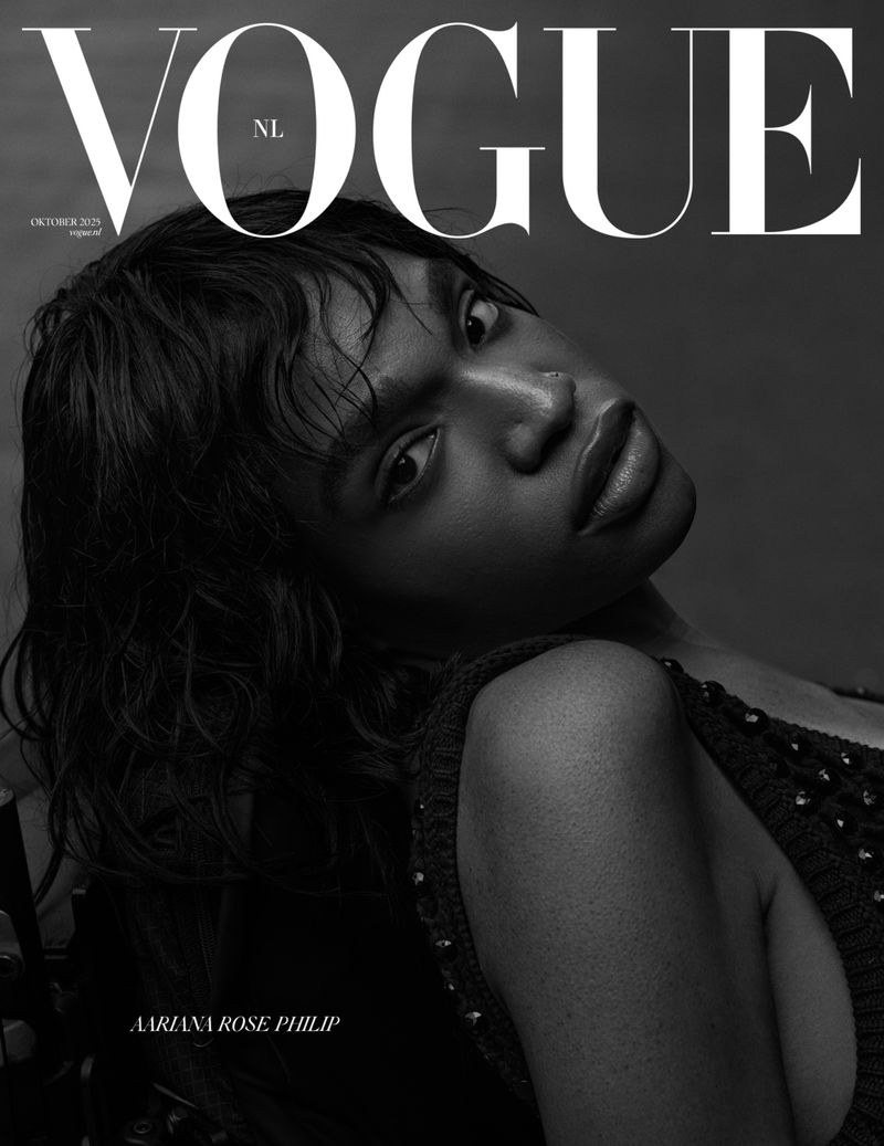 Black and white Vogue NL cover featuring a black female model with wet-look hair, looking at the camera against a gray backdrop.