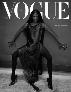 Richie Shazam poses against a textured wall in a fringed dress, dark tights, and stilettos for the black-and-white Vogue Netherlands cover.