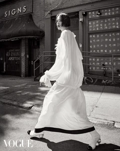 Model in a white dress walking down a city street for Vogue Hong Kong captured by Bridget Fleming