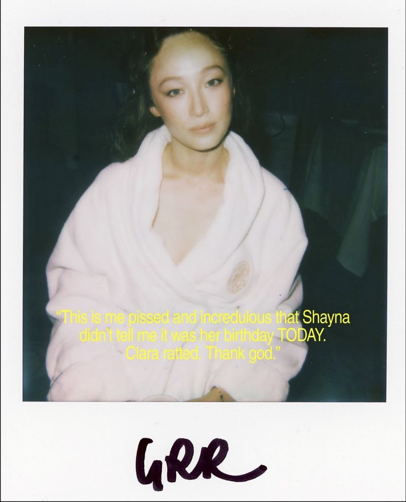 Portrait of a young adult woman in a white robe, captured in a candid polaroid-style photo with handwritten text below.
