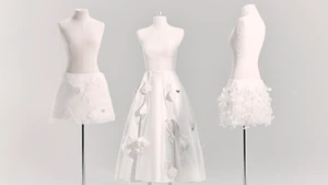 Three white tailor mannequins displaying white Prada skirts with 3D floral embellishments against a pale seamless studio background.
