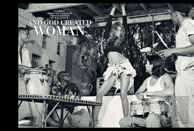 Monochrome fashion editorial shot with four people playing percussion instruments and a woman dancing with her arms raised.
