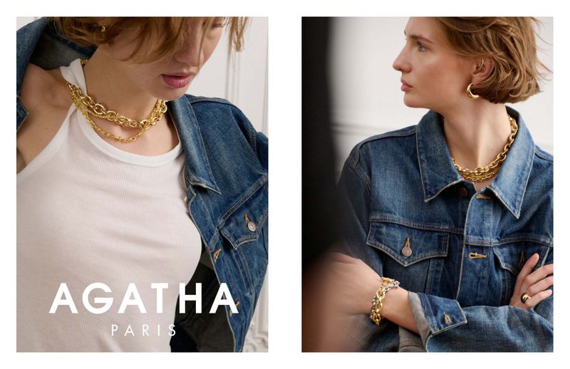 Close-up of a woman wearing a gold chain necklace and earrings with a blue denim jacket by Agatha Paris; beauty shot, fashion.