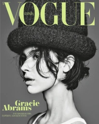 Black and white profile portrait of singer Gracie Abrams wearing a textured knit bucket hat for Vogue España cover.