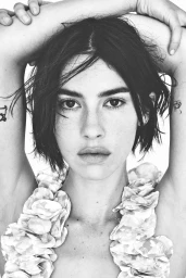 Gracie Abrams posing with arms raised for Vogue Espana, captured in monochrome by Daniel Jackson with hair styled by Ward Stegerhoek.