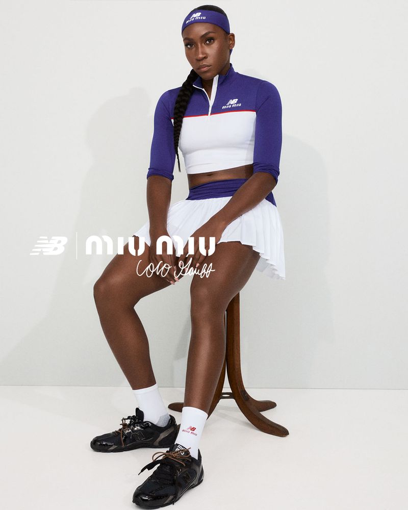 Coco Gauff in New Balance x Miu Miu campaign, seated on stool, wearing a white and purple tennis outfit and black tennis shoes.