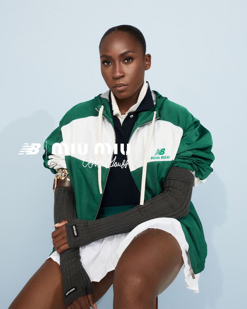 Cori Gauff sits in a photo studio wearing a green and white Miu Miu jacket and white pleated skirt for a fashion editorial.