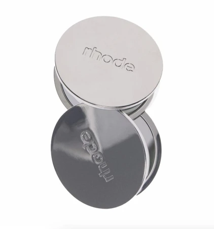 Stack of two shiny, silver-coloured circular containers with the brand name 'rhode' embossed on the top, isolated on a white background.