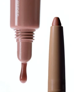 Close-up still life of a rhode Skin peptide lip shade tube with a product drop and a matching lip liner against white background
