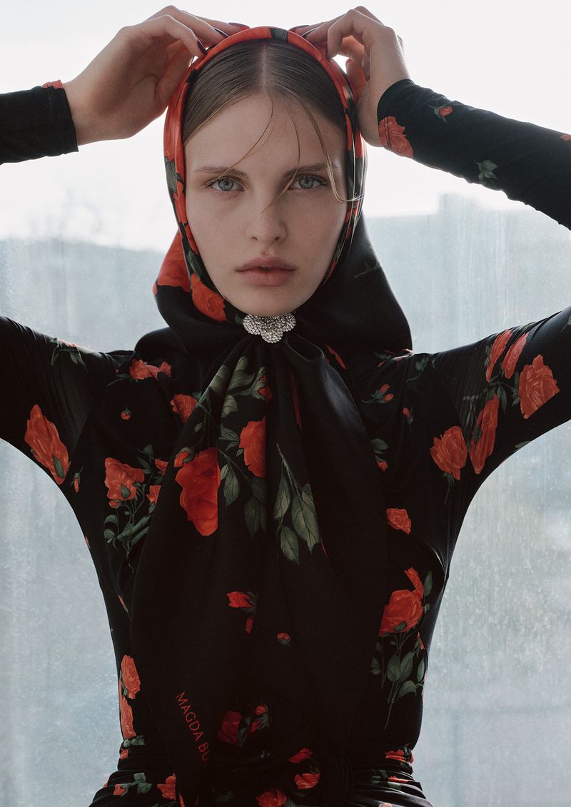 A fashion shot showcases a woman in a black, rose-patterned dress and headscarf, gazing intensely at the camera against a bright window.