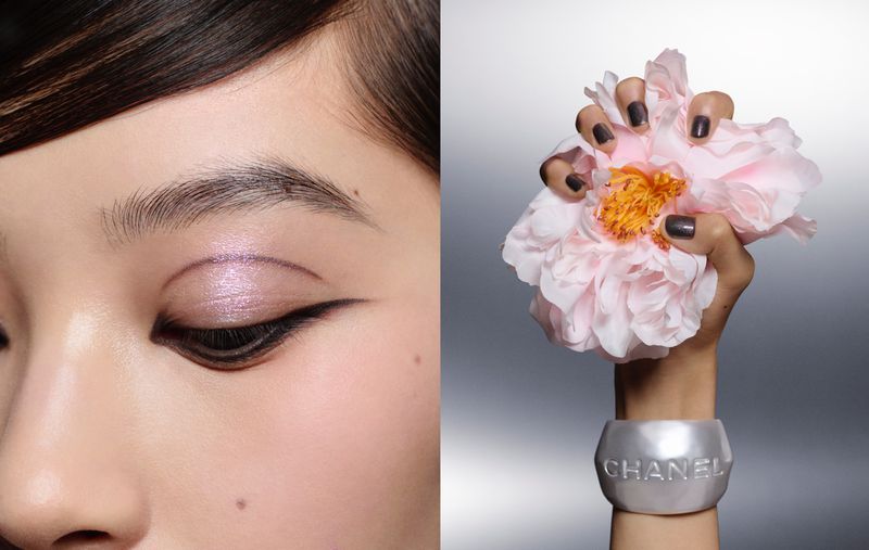 Close-up shot of a woman's eye with shimmery eyeshadow, paired with a hand holding a pink flower and wearing a Chanel bracelet.