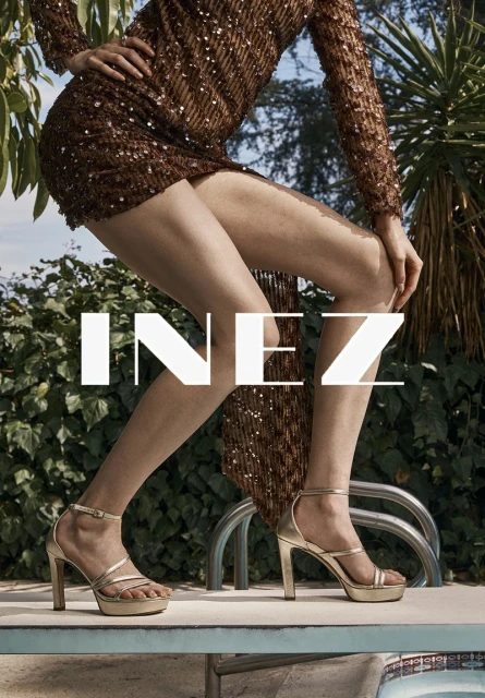 Woman in a short, sparkly dress and gold high heels poses poolside with green foliage; fashion, beauty, and summer lifestyle imagery.