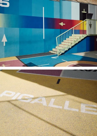 Outdoor view of a colorful public playground with a staircase, featuring blue, red, and yellow paint, and geometric shapes.