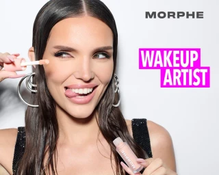 Close-up of a smiling woman holding a concealer wand, wearing hoop earrings and a black top against a white background with text.