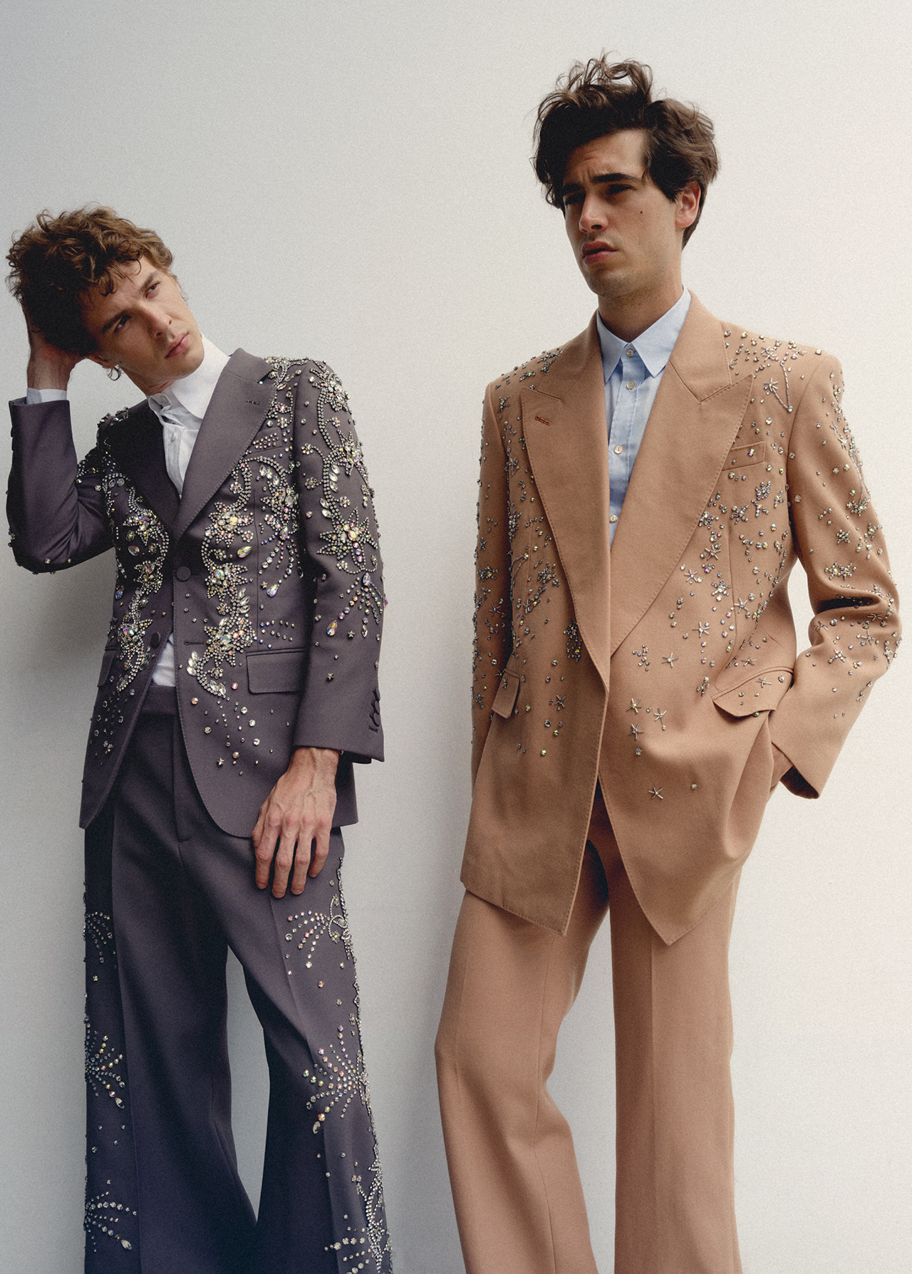 Two male models in embellished tailored suits standing against a plain white background for an Icon Magazine Australia editorial shoot.