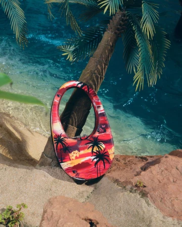 Fashionable handbag featuring tropical beach scene with palm trees against an ocean and sand background for a vibrant, summery aesthetic.