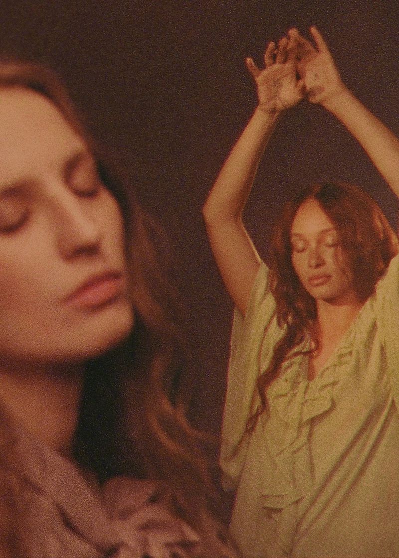 Two women posing with arms raised in a campaign by Petra Collins for And Other Stories with warm grain and analog styling.