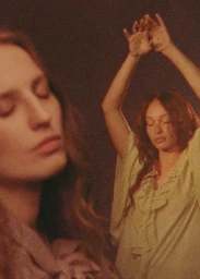 Two women posing with arms raised in a campaign by Petra Collins for And Other Stories with warm grain and analog styling.