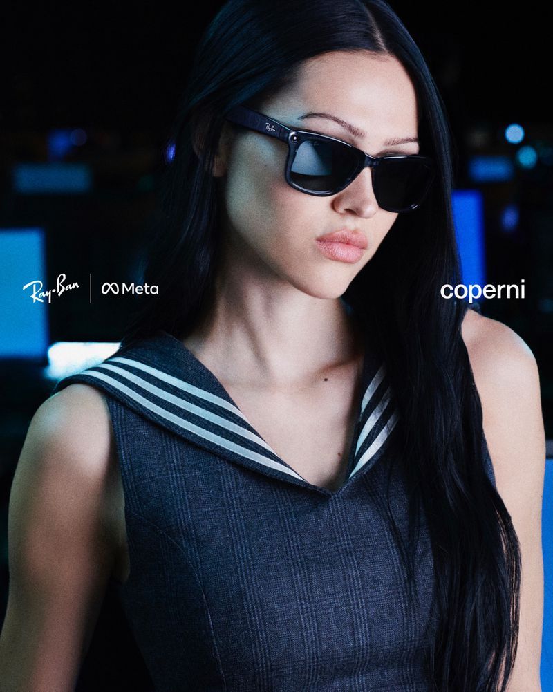 Brunette woman in a sailor-style top wearing dark sunglasses, with branding for Ray-Ban, Meta, and Coperni visible. Fashion shot.