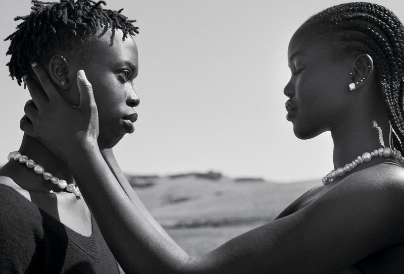 Black and white portrait of Adut Akech and Bior Akech facing each other in the project Two Of Us for Vogue Australia.
