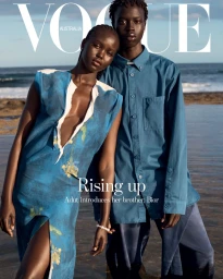 Adut Akech and her brother Bior posing together by the ocean for a Vogue Australia magazine cover styled by Justin Woo.